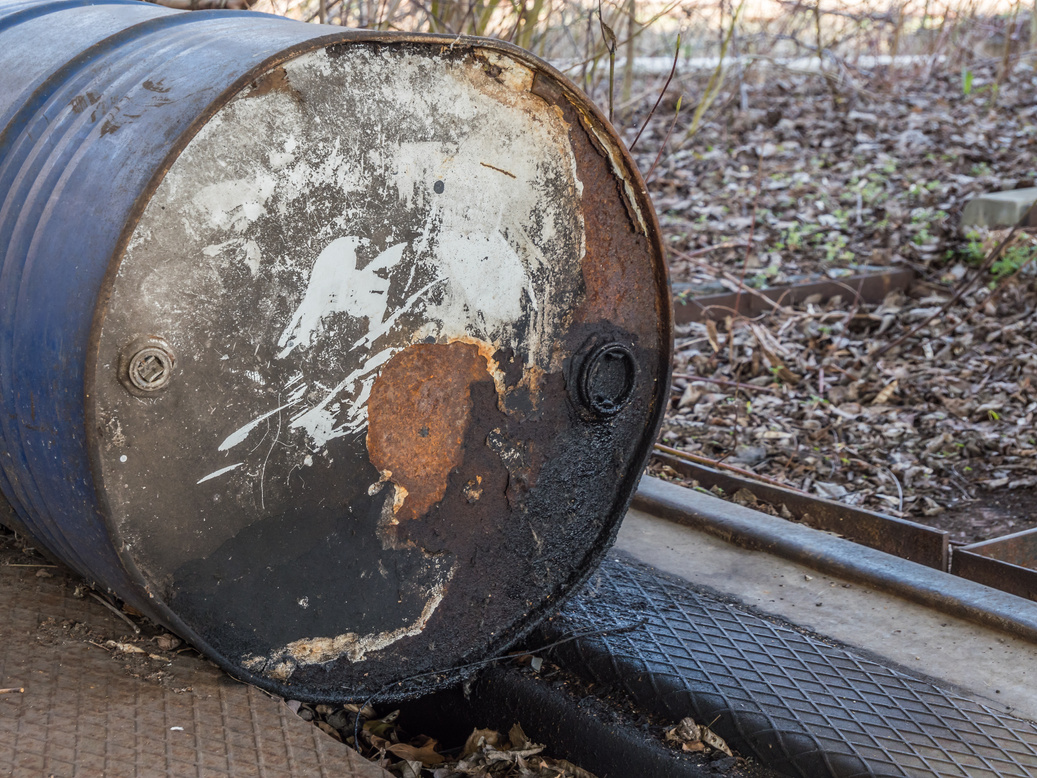 Old oil drum in nature. Pollution